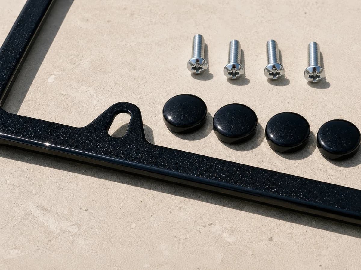 Black Sapphire Metallic plate frame up close — frame, screw caps, and hardware